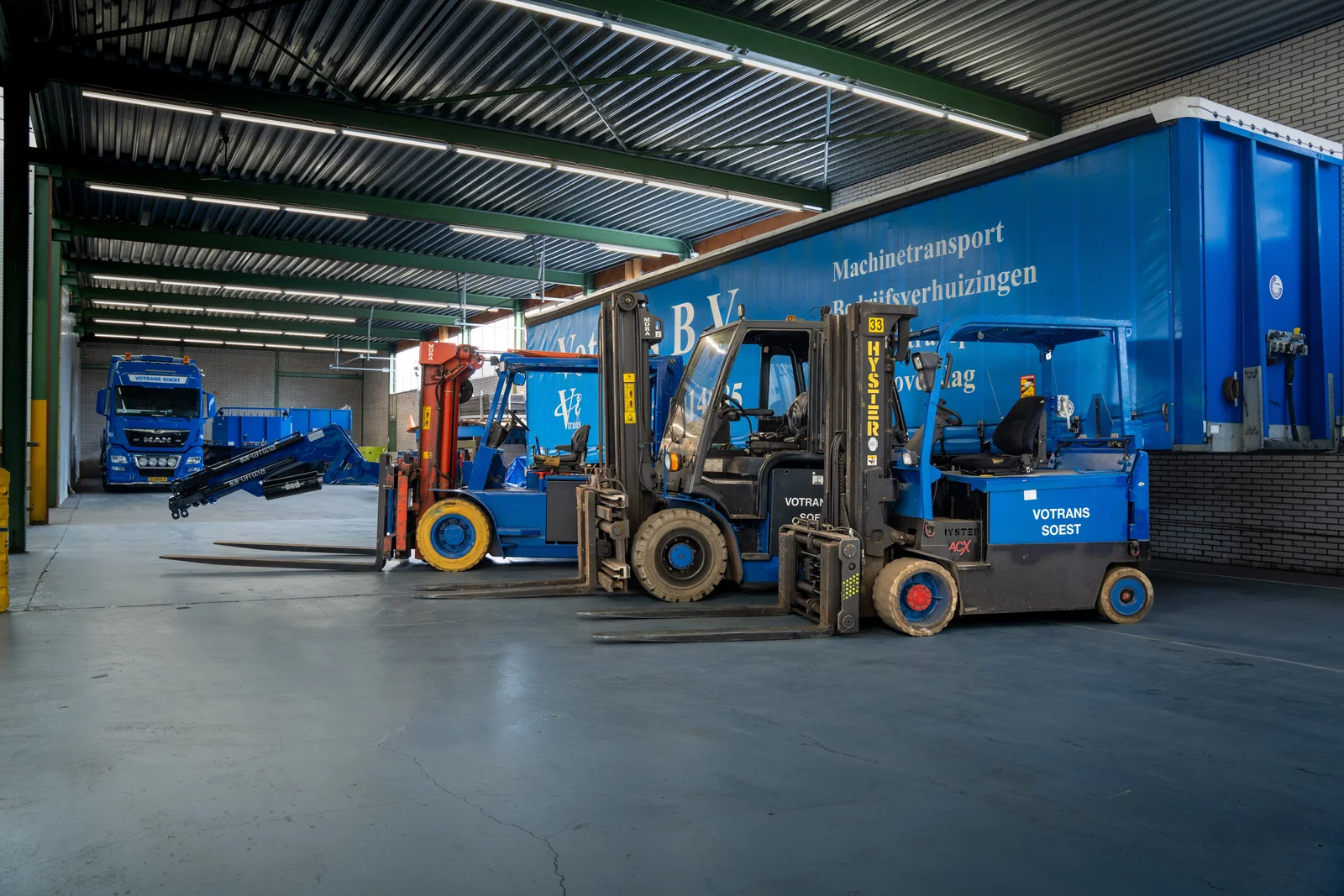 Heftrucks en vrachtwagens van Votrans in de loods